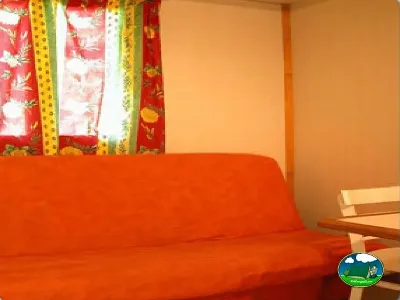 Mobil-home interior con sofá rojo del Camping Puente de las Herrerías, Cazorla (Jaén)