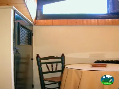 Interior de tienda de acampada con cama y mobiliario del Camping Puente de las Herrerías, Cazorla (Jaén)