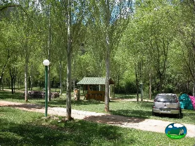 Parcela arbolada con cabaña y coche del Camping Puente de las Herrerías, Cazorla (Jaén)