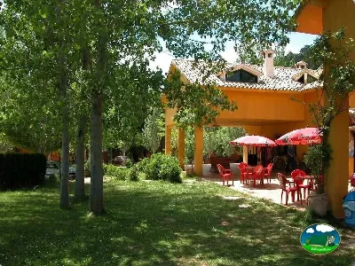 Restaurante con terraza sombreada bajo árboles del Camping Puente de las Herrerías, Cazorla (Jaén)