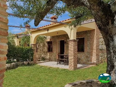 Cabaña de piedra y ladrillo con parcela y porche del Camping Las Cañadas, Baños de Montemayor (Cáceres)