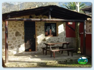 Cabaña de piedra con terraza y mesa de picnic del Camping El Pinajarro, Hervás (Cáceres)