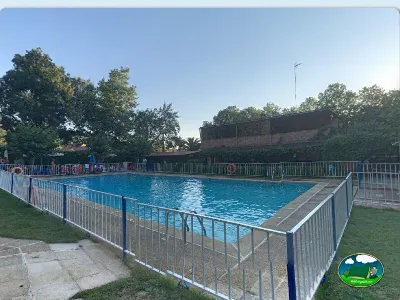 Piscina con vistas al jardín y zonas verdes del Camping El Pinajarro, Hervás (Cáceres)