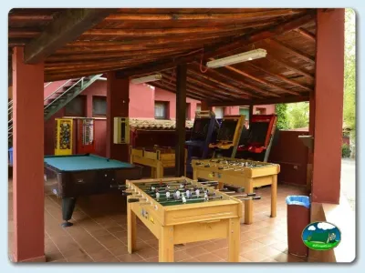 Sala de juegos cubierta con futbolín, billar y máquinas arcade del Camping El Pinajarro, Hervás (Cáceres)