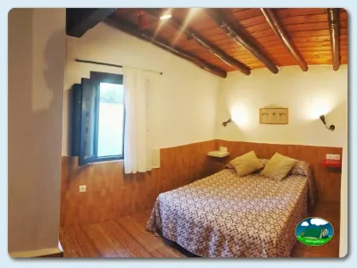 Cabaña interior con cama doble y techo de madera del Camping El Pinajarro, Hervás (Cáceres)