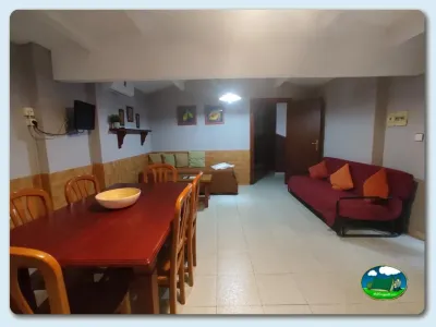 Sala común con mesa de comedor y sofá del Camping El Pinajarro, Hervás (Cáceres)