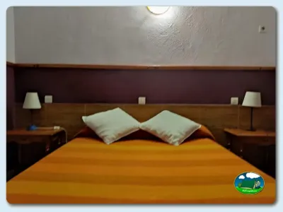 Habitación con cama doble y mesillas del Camping El Pinajarro, Hervás (Cáceres)
