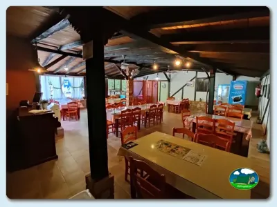 Restaurante con mesas y sillas de madera del Camping El Pinajarro, Hervás (Cáceres)