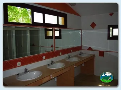 Aseos con lavabos y espejos del Camping El Pinajarro, Hervás (Cáceres)