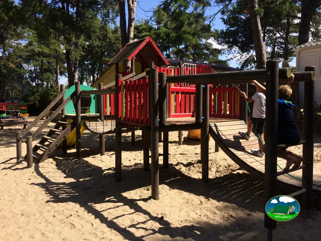 Parque infantil entre pinos del Camping Le Bois Dormant, QUEND (Somme)