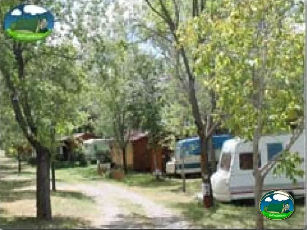 Parcela arbolada con caravana del Camping El Pinar de Hoyocasero, Hoyocasero (Ávila)