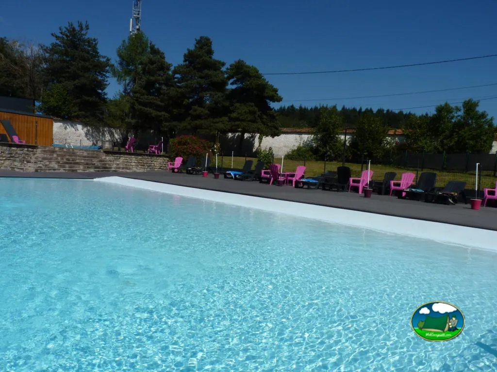 Piscina exterior con tumbonas del Camping Le Manoir de Bezolle, SAINT-PÉREUSE (Nièvre)
