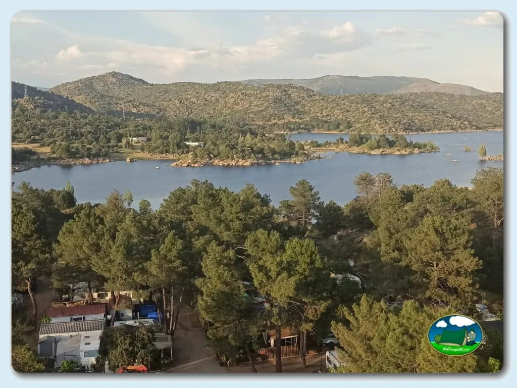 Lago con vistas a la sierra, parcelas entre pinos del Camping Pantano del Burguillo, El Barraco (Ávila)