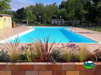 Piscina rodeada de jardines del Camping La Mariflaude, HOURTIN (Gironda)