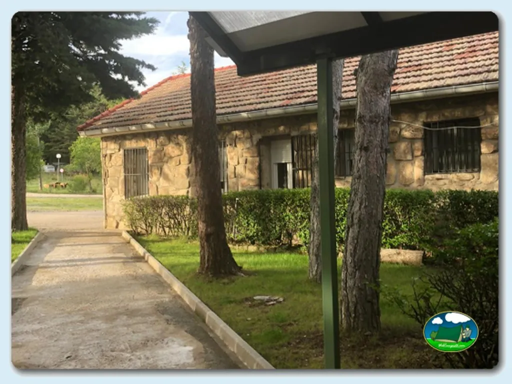 Cabaña de piedra con porche y jardín del Camping La Nava, Peguerinos (Ávila)
