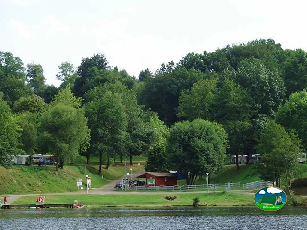 lago con cabañas entre árboles
