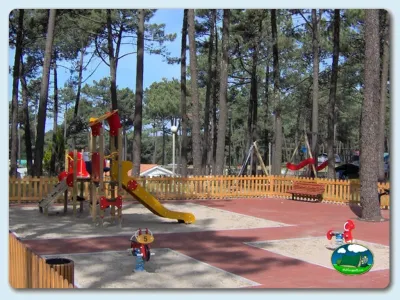 Parque infantil entre pinos con tobogán y columpios del Camping Inatel, Cabedelo (Viana Do Castelo)