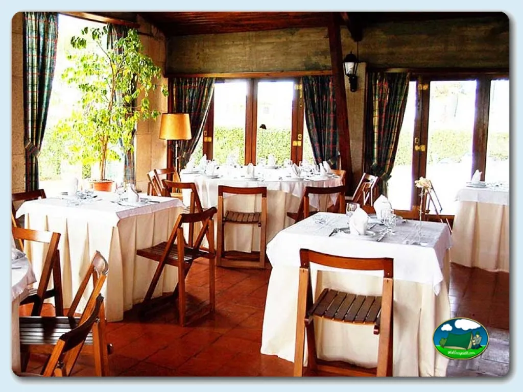 Restaurante interior con mesas redondas y vistas al jardín del Camping Orbitur Angeiras, Matosinhos (Porto)