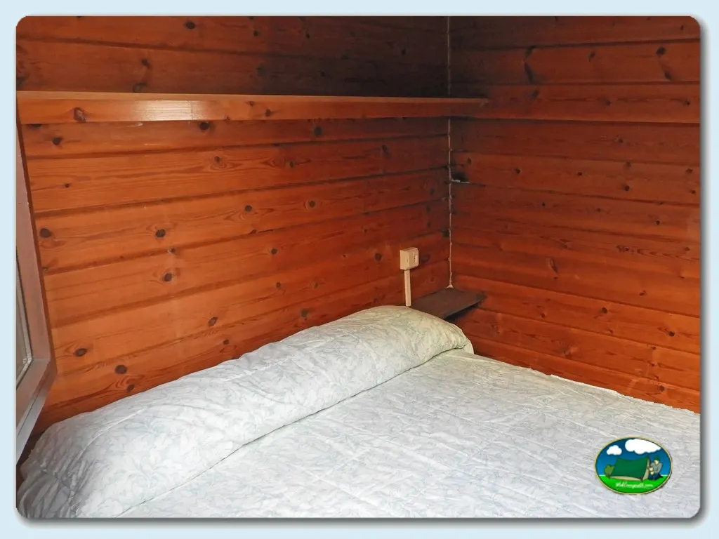 Interior cabaña de madera con cama doble del Camping Mougas, Oia (Pontevedra)