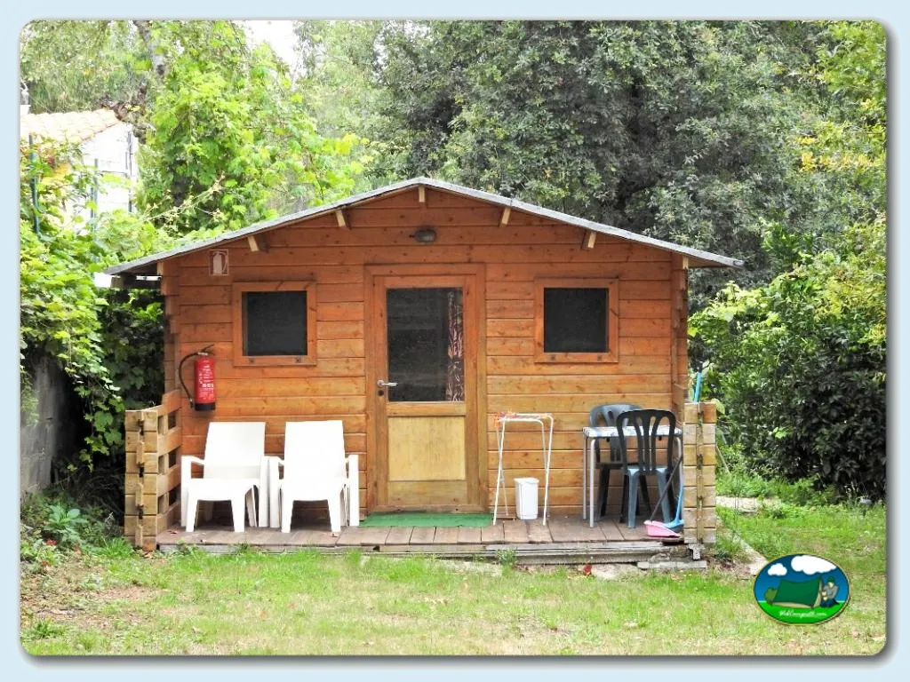 Cabaña de madera con terraza y mobiliario exterior del Camping Convívio, Candemil (Viana Do Castelo)