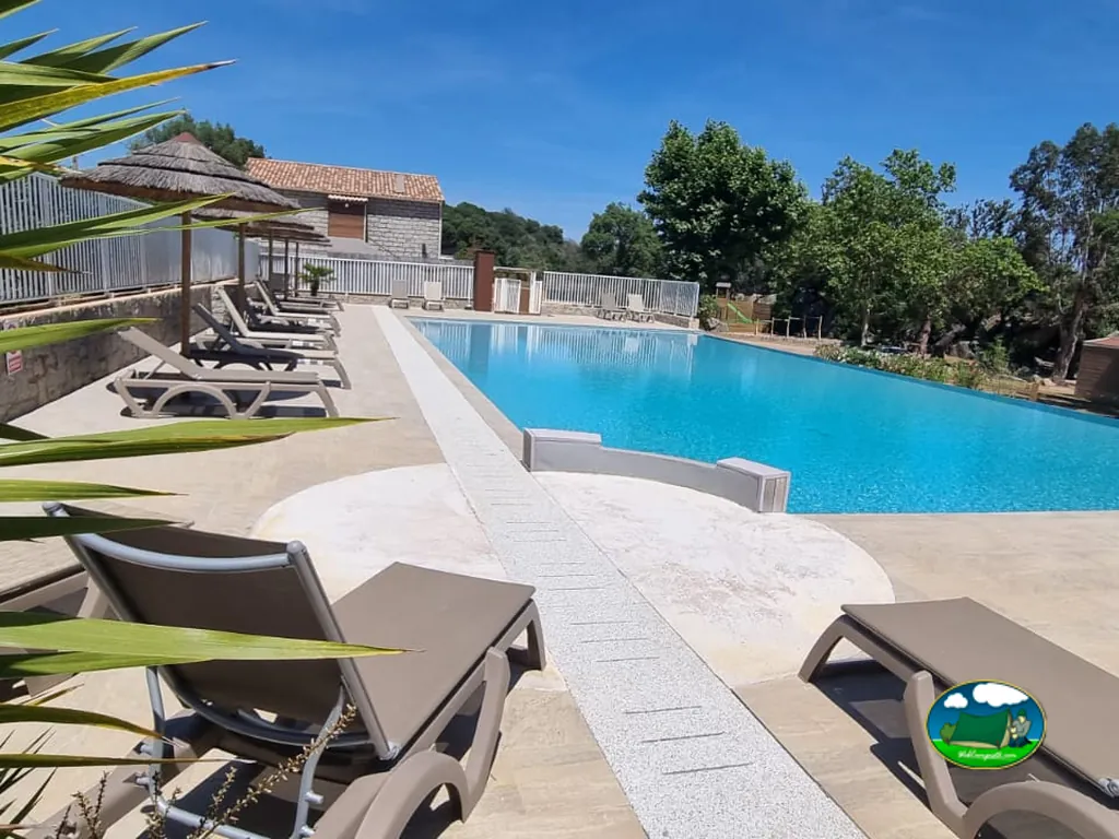 Piscina y terraza con tumbonas de Camping La Baie des Voiles, Porto-Vecchio