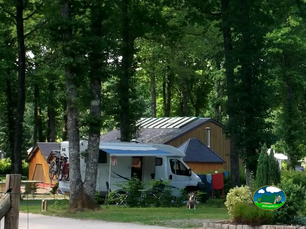 Autocaravana entre árboles y cabañas