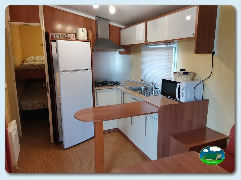 Mobil-home interior con cocina equipada y dormitorio del Camping Sol y Mar, O Grove (Pontevedra)