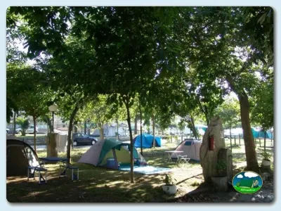 Parcela con tienda de acampada bajo árboles del Camping Moreiras, Moreires (Pontevedra)