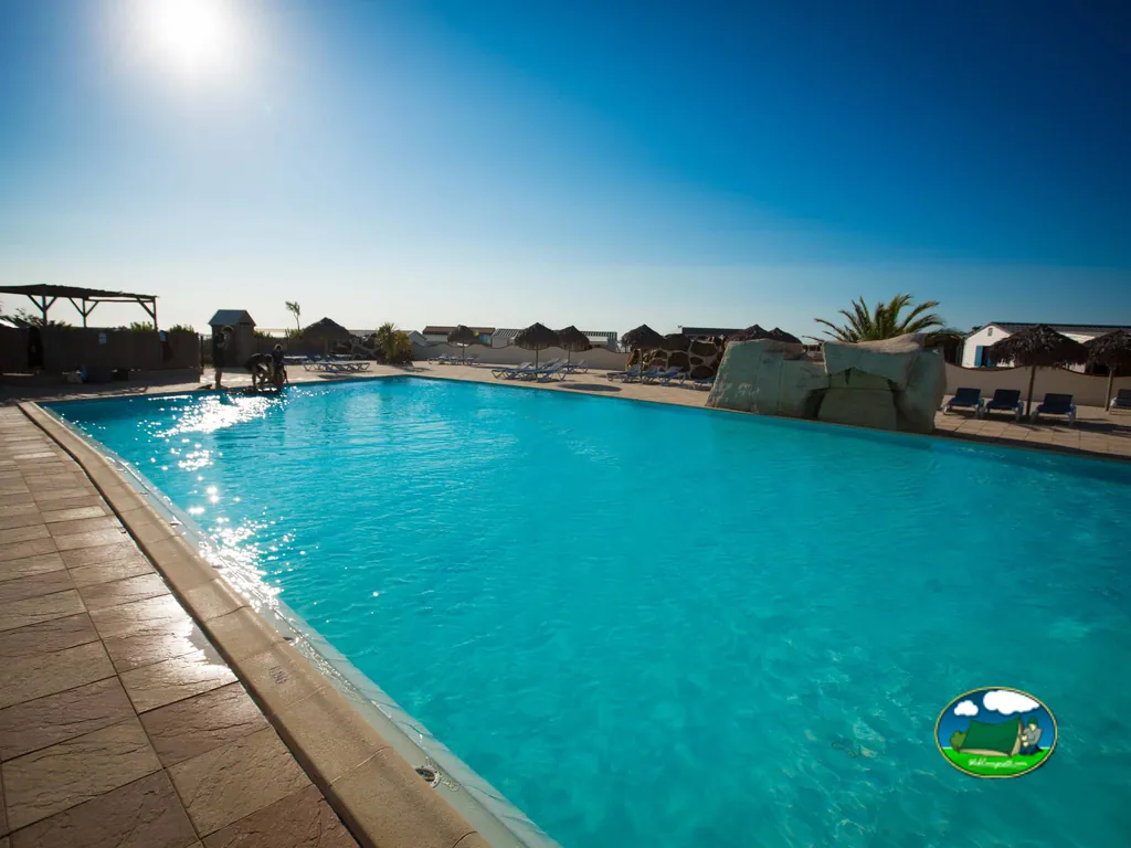 Piscina con sombrillas de paja