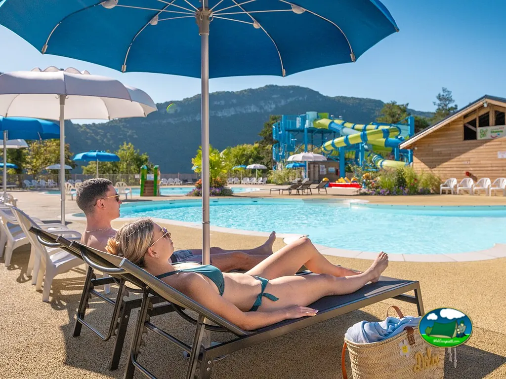 pareja descansando junto a piscina