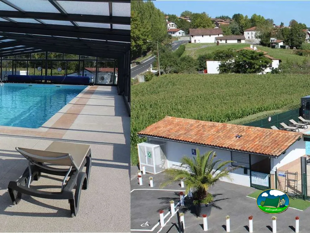piscina cubierta y vista aérea del camping con edificios de tejado rojo entre colinas verdes en Saint-Pée-sur-Nivelle