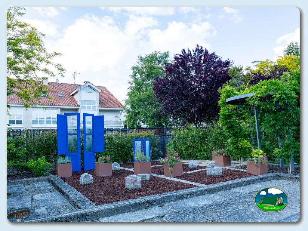 Parque infantil con estructura azul y huerto del Camping Os Invernadeiros, Allariz (Ourense)