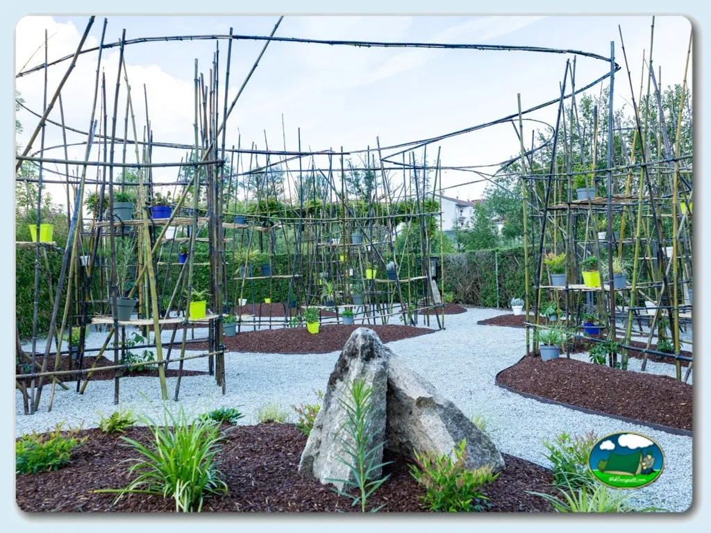 Parque infantil con estructuras de trepa y plantas del Camping Os Invernadeiros, Allariz (Ourense)
