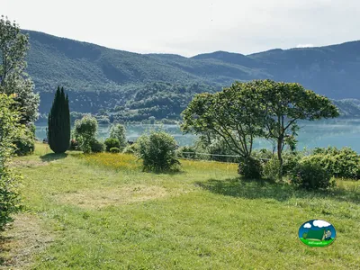 césped del camping con vistas al lago de Aiguebelette y montañas boscosas