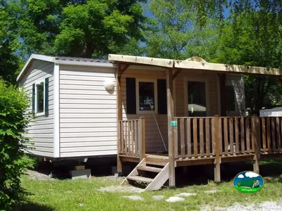 mobil-home con terraza de madera y escalera de acceso en el camping
