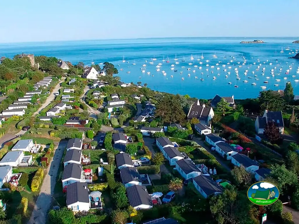 vista aérea de las parcelas del camping junto a la bahía de Cancale con veleros fondeados