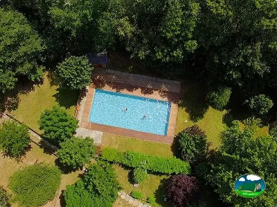 Piscina rodeada de árboles y zonas verdes del Camping Caurel, Folgoso do Caurel (Lugo)