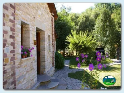 Cabaña de piedra con jardín y flores del Camping Valle do Seo, Trabadelo (León)