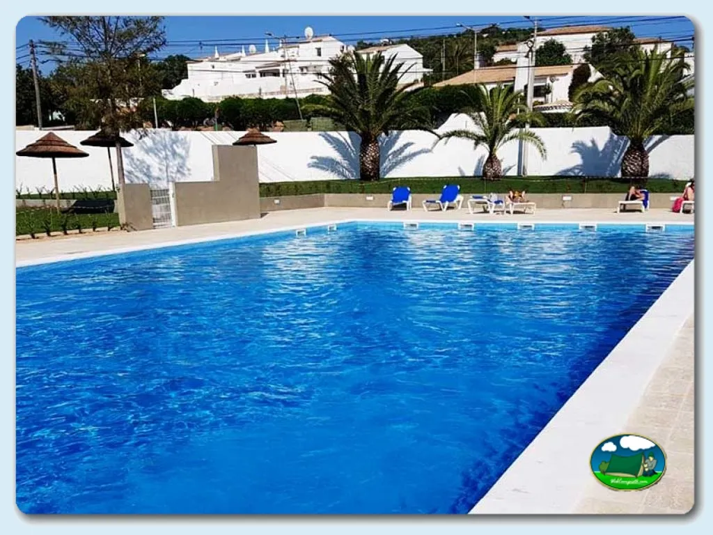 Piscina con vistas a bungalows y palmeras del Camping Orbitur Valverde, Lagos (Faro)