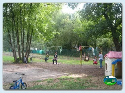 Parque infantil con árboles y equipos de juego del Camping Green Village, Bergondo (A Coruña)