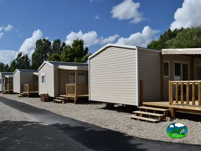 hilera de mobile homes con terrazas de madera en el camping de Pont-sur-Seine