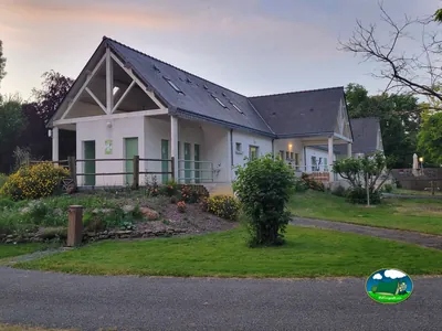 edificio de recepción y sanitarios del camping con jardín al anochecer en Savigny-en-Véron