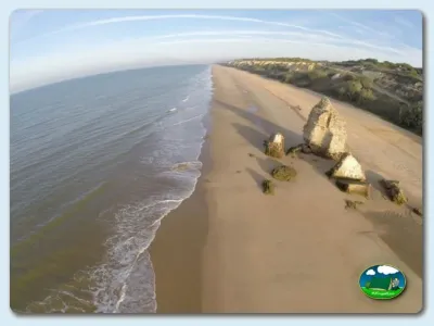 Playa junto al mar con acantilados y restos de estructuras históricas del Camping Doñana Playa, Matalascañas (Huelva)