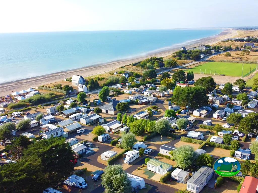 vista aérea del camping junto a la playa con hileras de mobile homes y caravanas en Donville-les-Bains