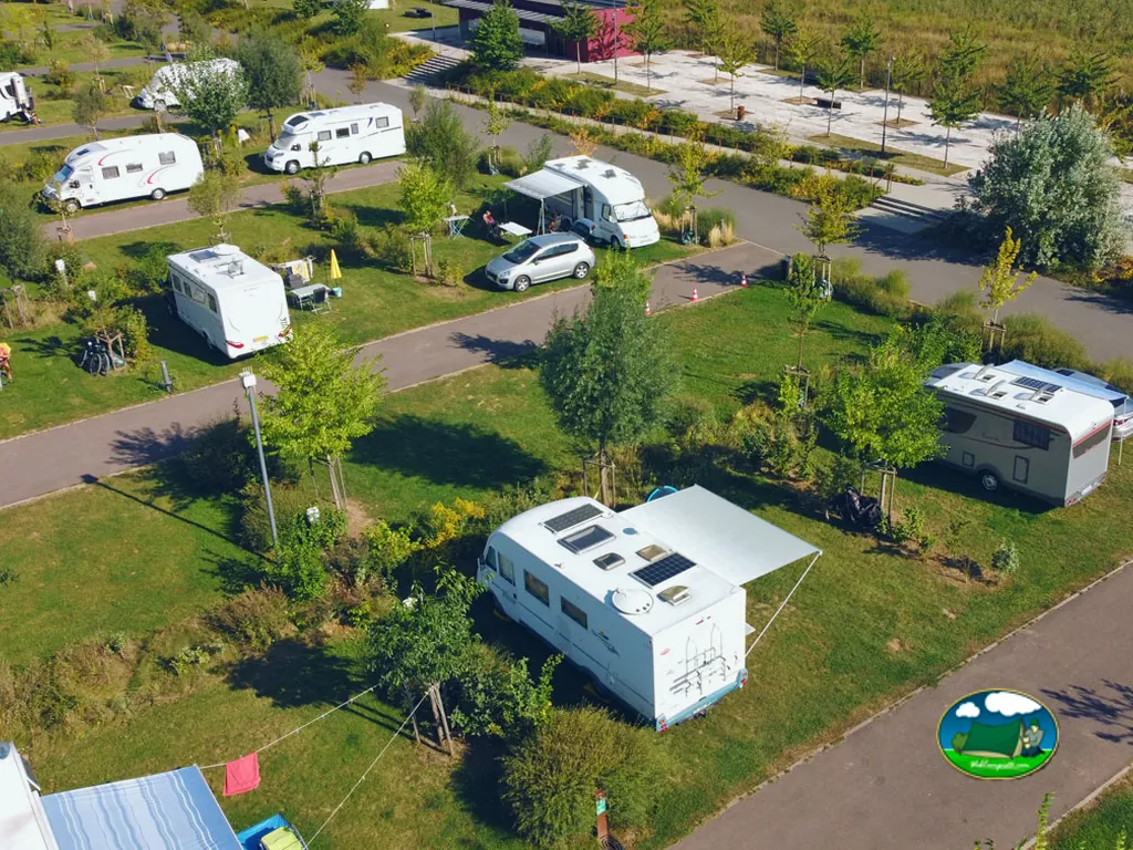 vista aérea de caravanas y autocaravanas estacionadas entre parcelas ajardinadas del camping en Basse-Ham