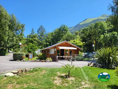 recepción de madera del camping con montañas al fondo en Louvie-Juzon