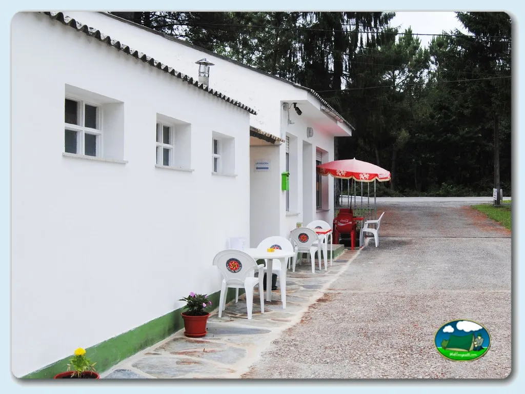 Restaurante bar con terraza y sombrilla roja del Camping El Mesón, Guitiriz (Lugo)