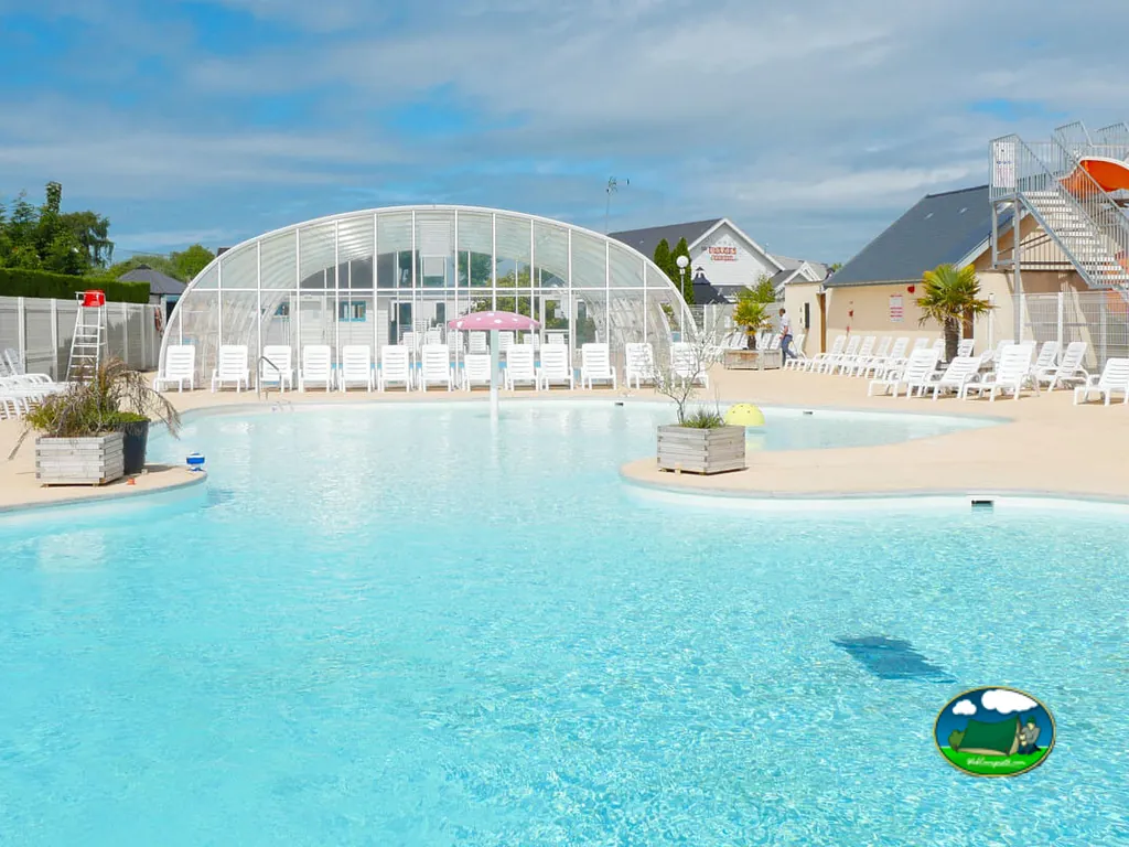 piscina cubierta con tumbonas y tobogán del camping en Fort-Mahon-Plage