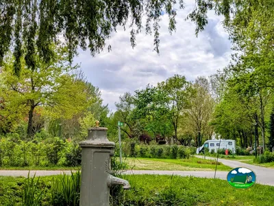 fuente de agua antigua junto al camino del camping con una autocaravana al fondo en Neuilly-sur-Marne
