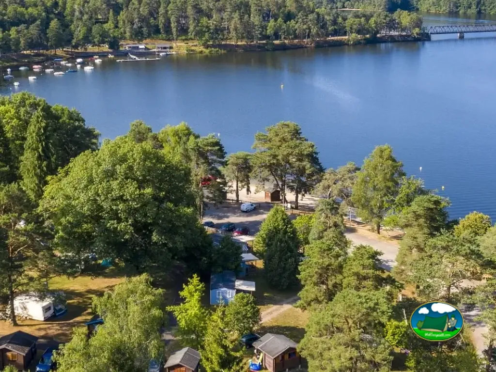 vista aérea del camping arbolado junto al lago en Marcillac-la-Croisille